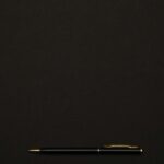 A sleek black pen placed on a minimalist dark background, perfect for professional presentations.